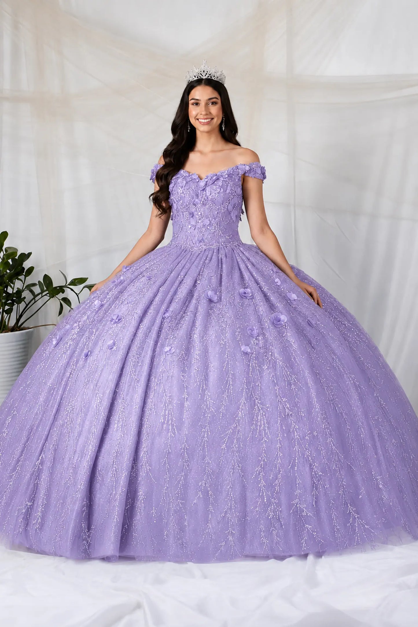 Front view of a lilac quinceanera dress with 3D floral appliques, glittered fabric, and detachable sheer flowing cape