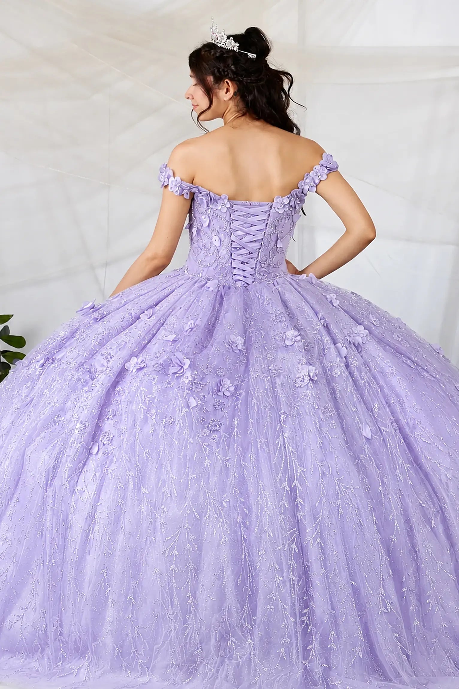 Back view of a lilac quinceanera dress with lace-up corset, 3D floral appliques and glitter tulle skirt