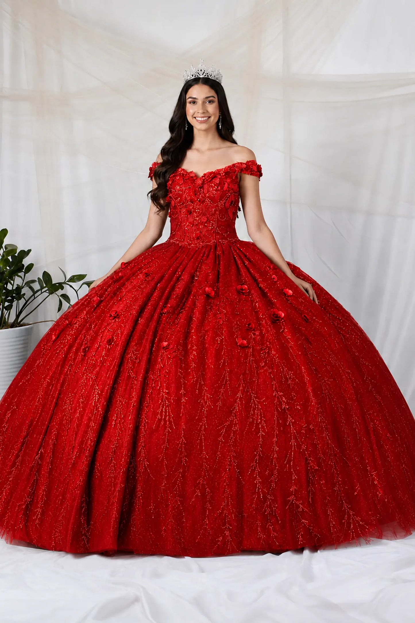 Front view of a red quinceanera dress with 3D floral appliques, glittered fabric, and detachable sheer flowing cape