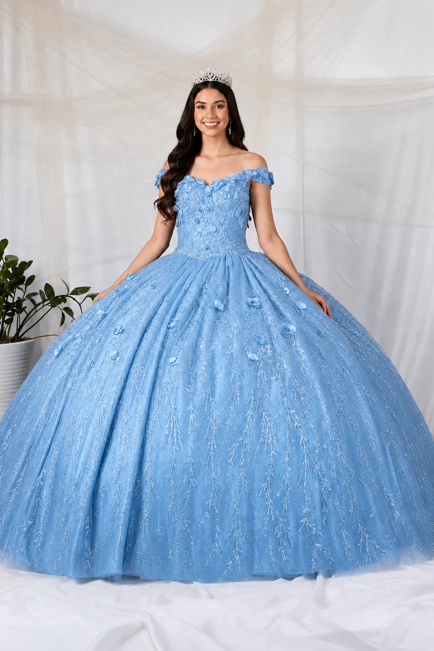 Front view of a sky blue quinceanera dress with 3D floral appliques, glittered fabric, and detachable sheer flowing cape