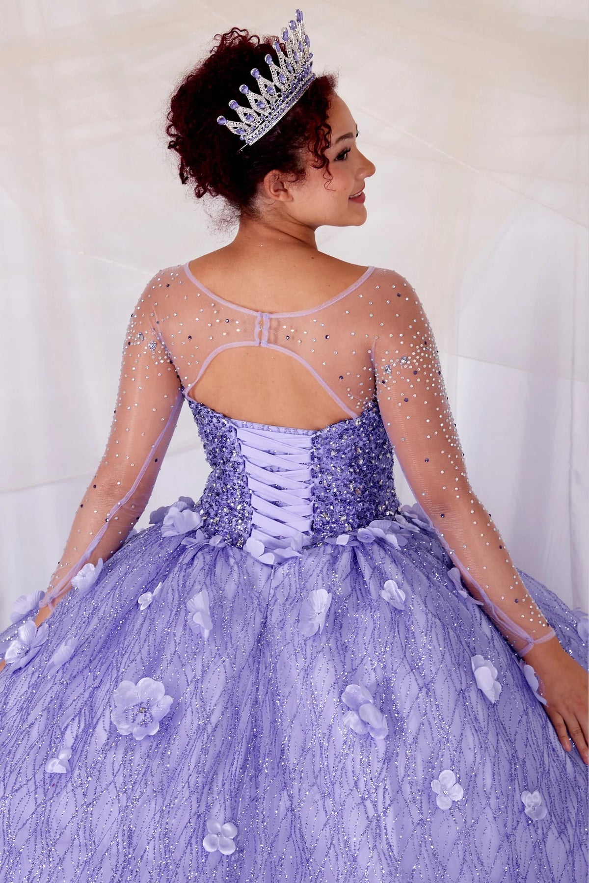 Sheer embroidery and a lace-up waist define the upper back of the Lilac quinceañera dress.