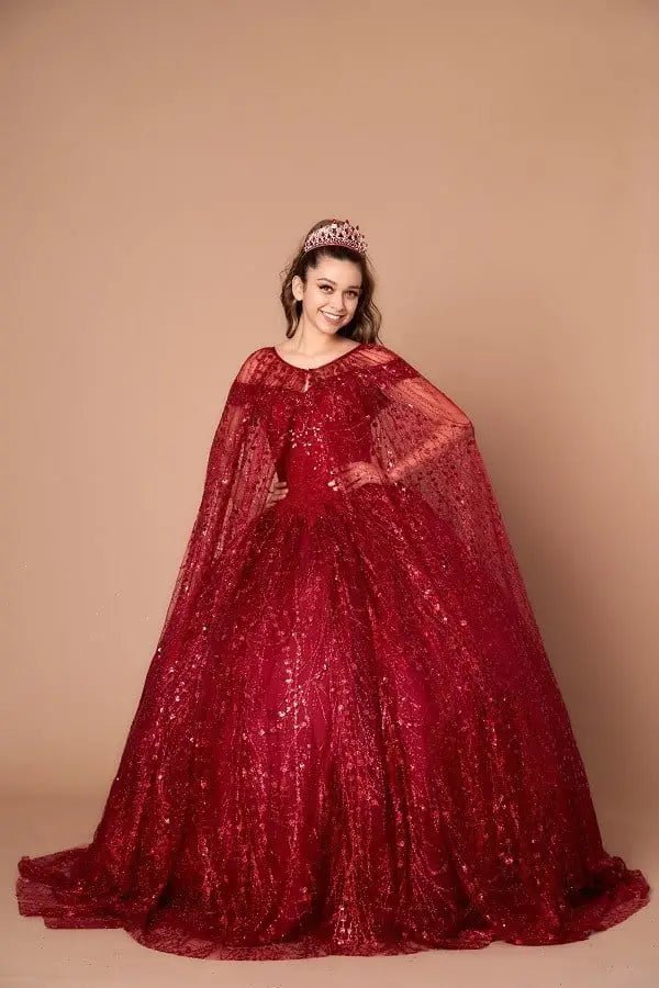 Front-Facing of a woman wearing Burgundy ball gown with off-shoulder neckline glittering sequins and full flowing skirt with elegant cape