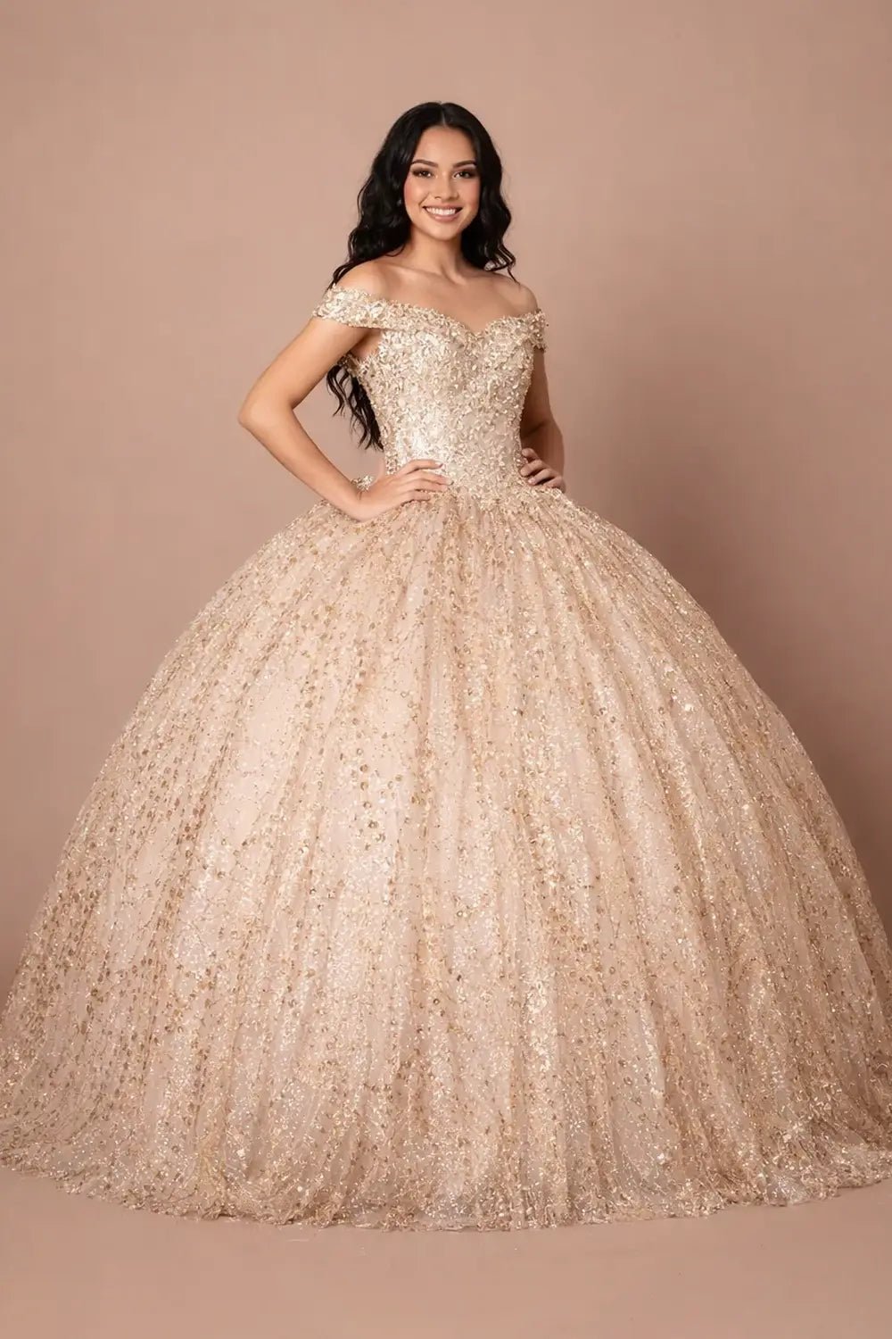 Front-Facing of a woman wearing Champagne ball gown with off-shoulder neckline sequin embellishments and flowing skirt complemented by cape