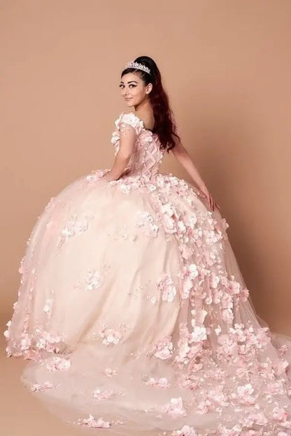 Back-Facing of a woman wearing Blush formal gown featuring extended tail layered skirt and soft silhouette