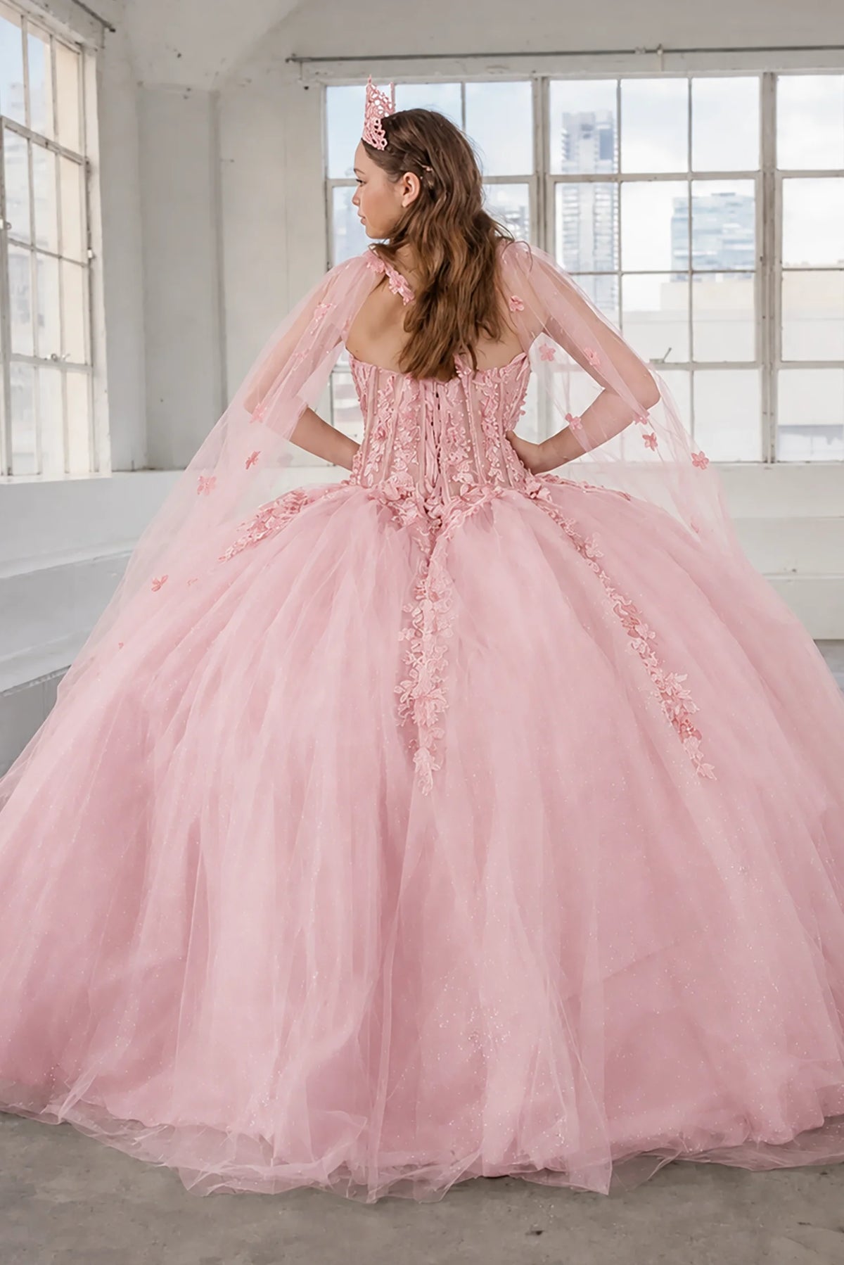 From behind, the Bubble Pink quinceañera ball gown reveals a shaped lace-up back and the sweep of the full skirt.