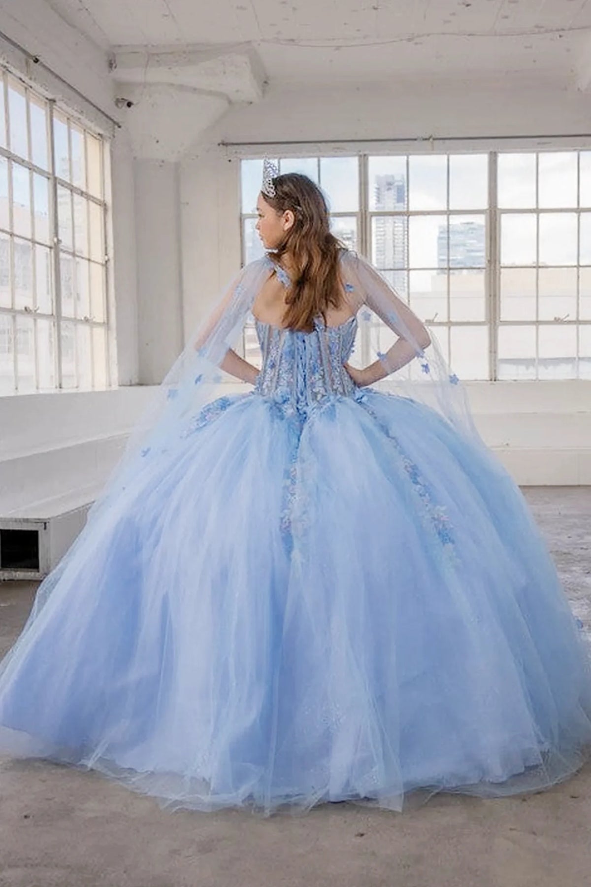 From behind, the Light Blue quinceañera ball gown reveals a shaped lace-up back and the sweep of the full skirt.