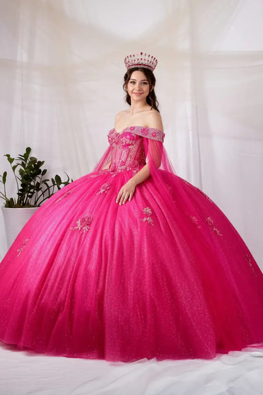 Side View of a woman wearing Bright pink gown with lace bodice off-shoulder styling and soft flowing silhouette enhanced by cape