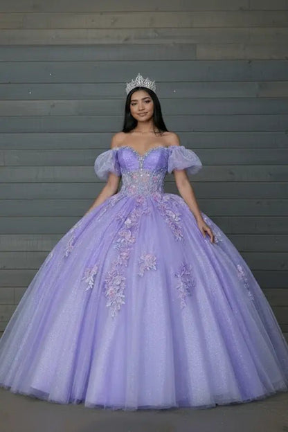 Front-Facing of a woman wearing Lilac gown featuring lace-up back flowing glitter tulle skirt and detachable cape detail