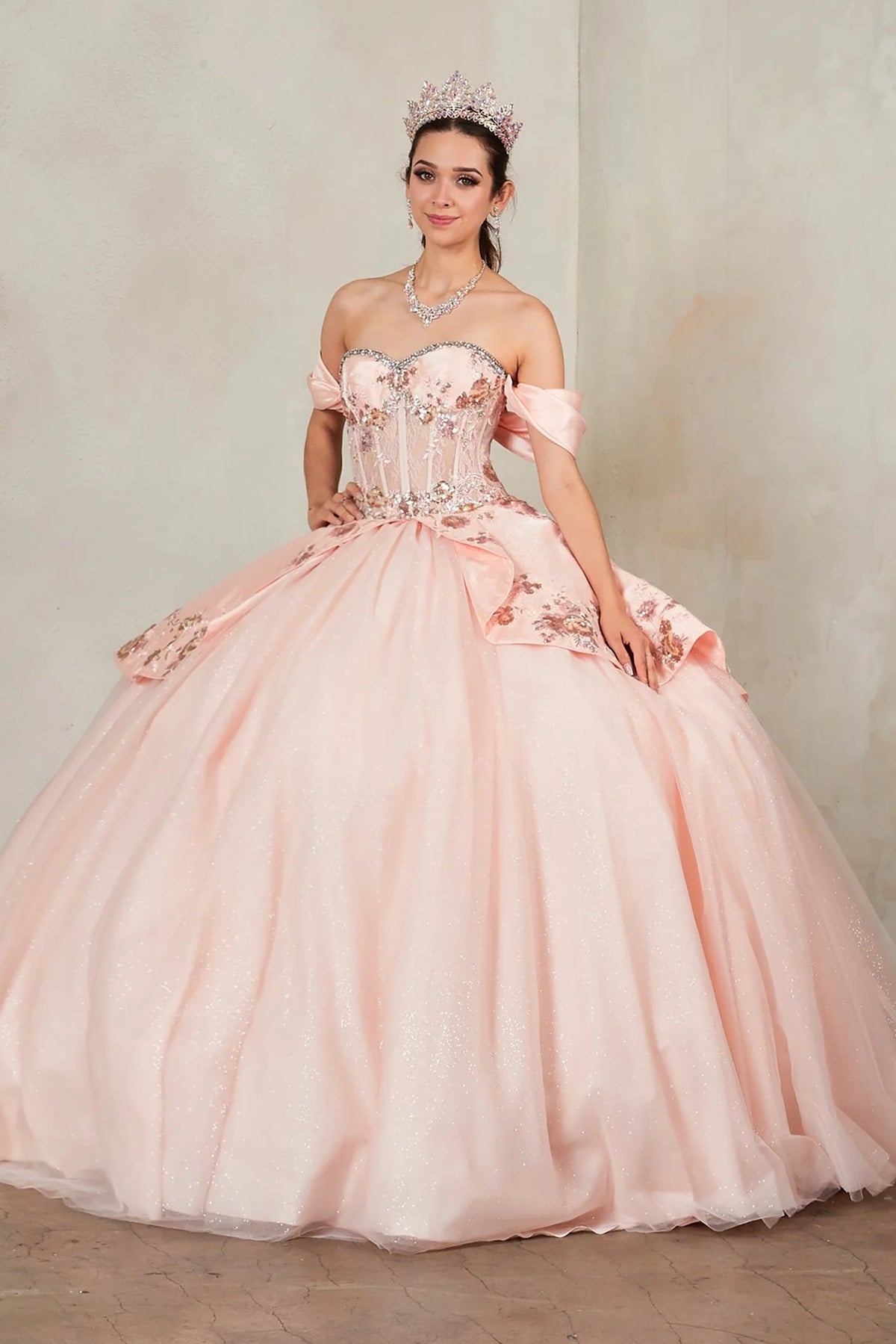Blush Pink quinceañera dress showcases jeweled satin bodice with embroidered peplum above glitter tulle skirt and lace-up back.
