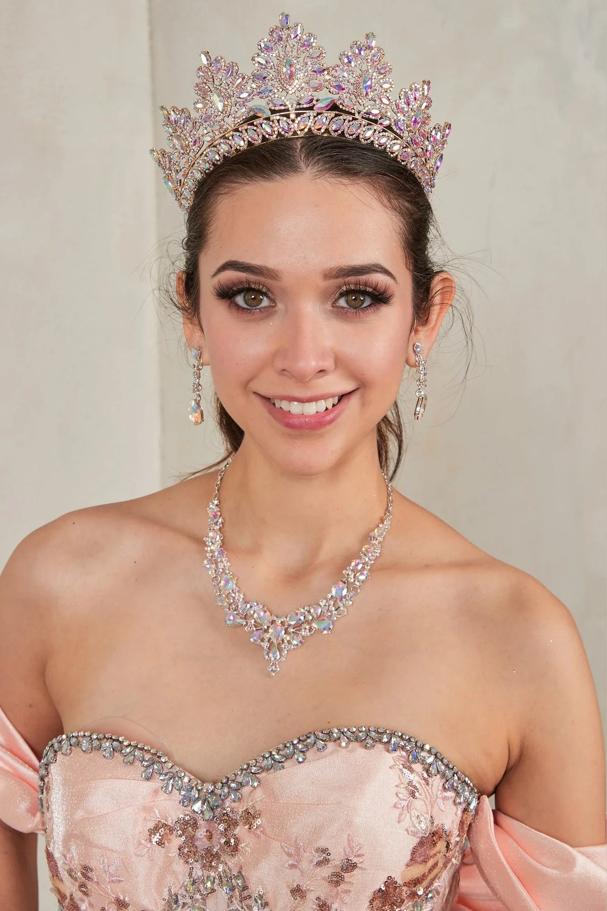 Jeweled satin bodice with embroidered peplum defines the Blush Pink quinceañera dress in this detailed view.