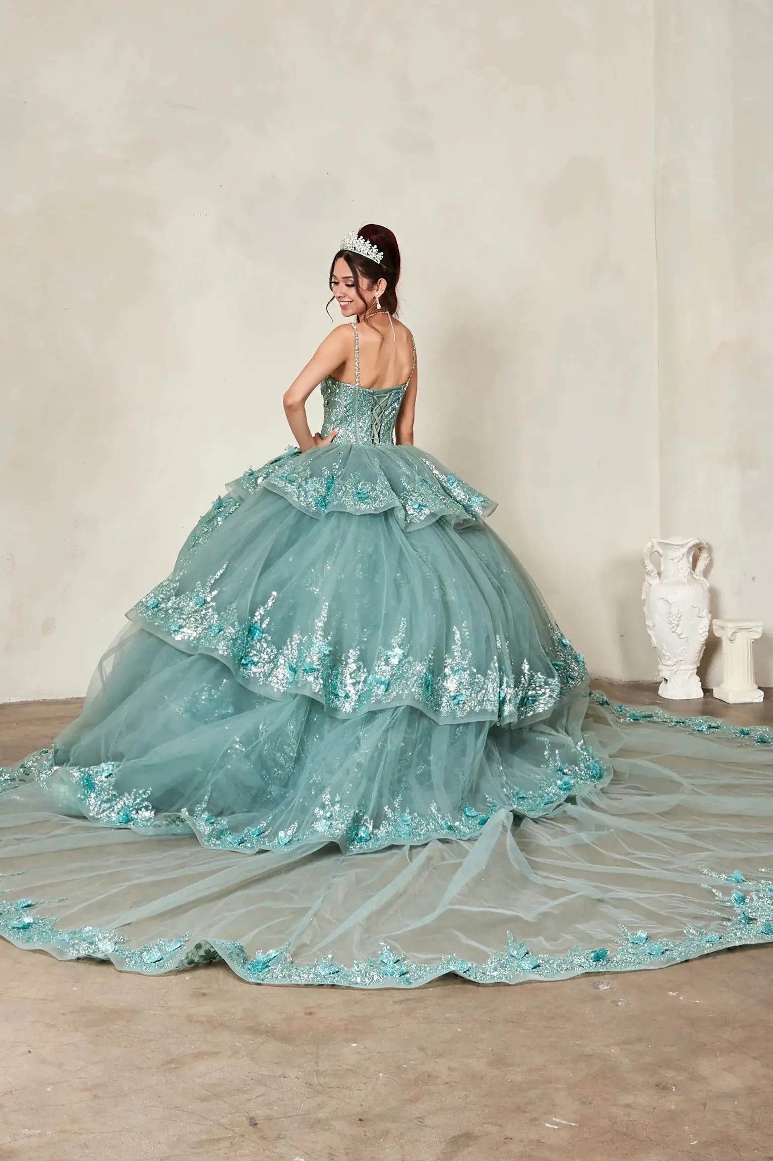 mint green quinceañera ball gown with intricate floral lace appliques and a long matching train