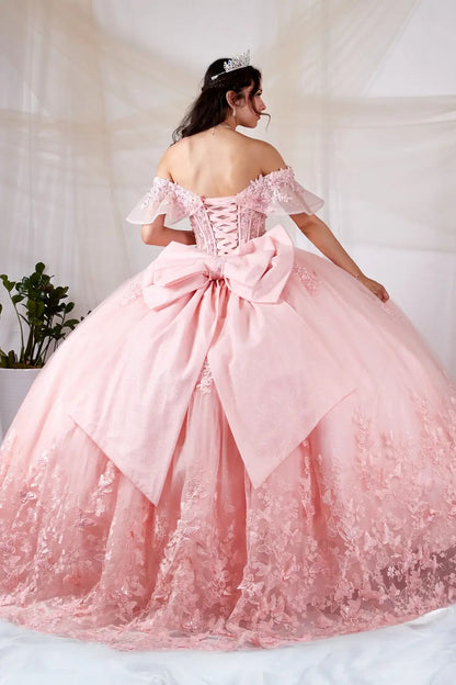 Back-Facing of a woman wearing Blush formal gown featuring structured back flowing glitter tulle skirt and soft silhouette