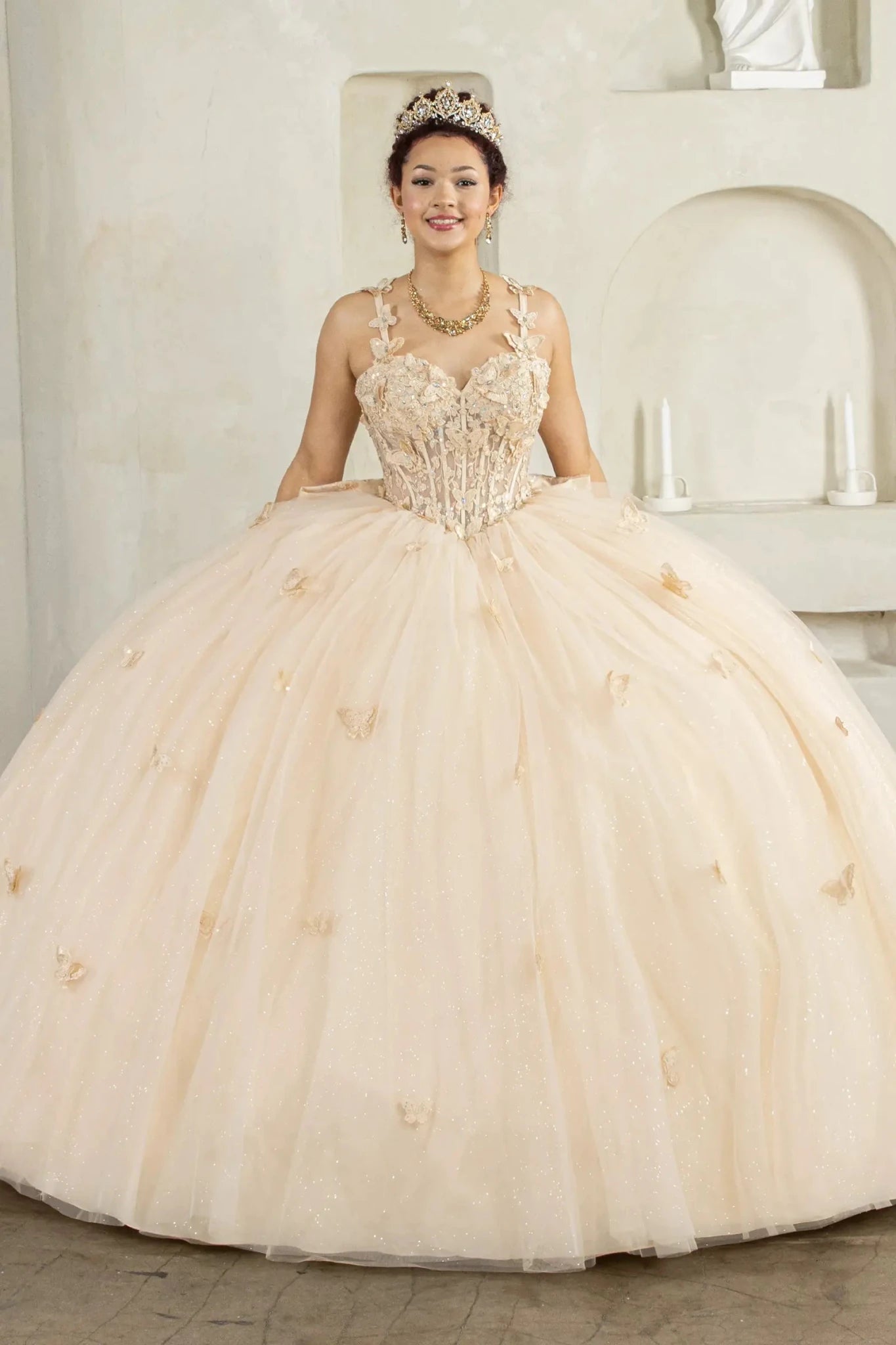 Front-Facing of a woman wearing Champagne ball gown with 3D butterfly appliqués on straps layered tulle skirt and removable bow