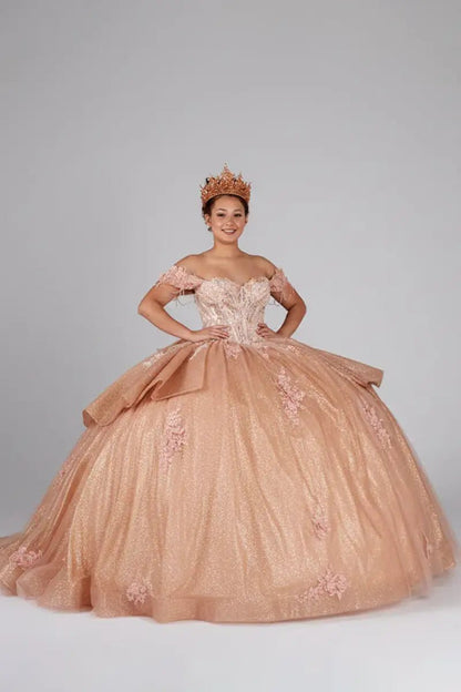 Front-Facing of a woman wearing Rose gold formal gown featuring lace-up back ruffled skirt overlay and chapel train