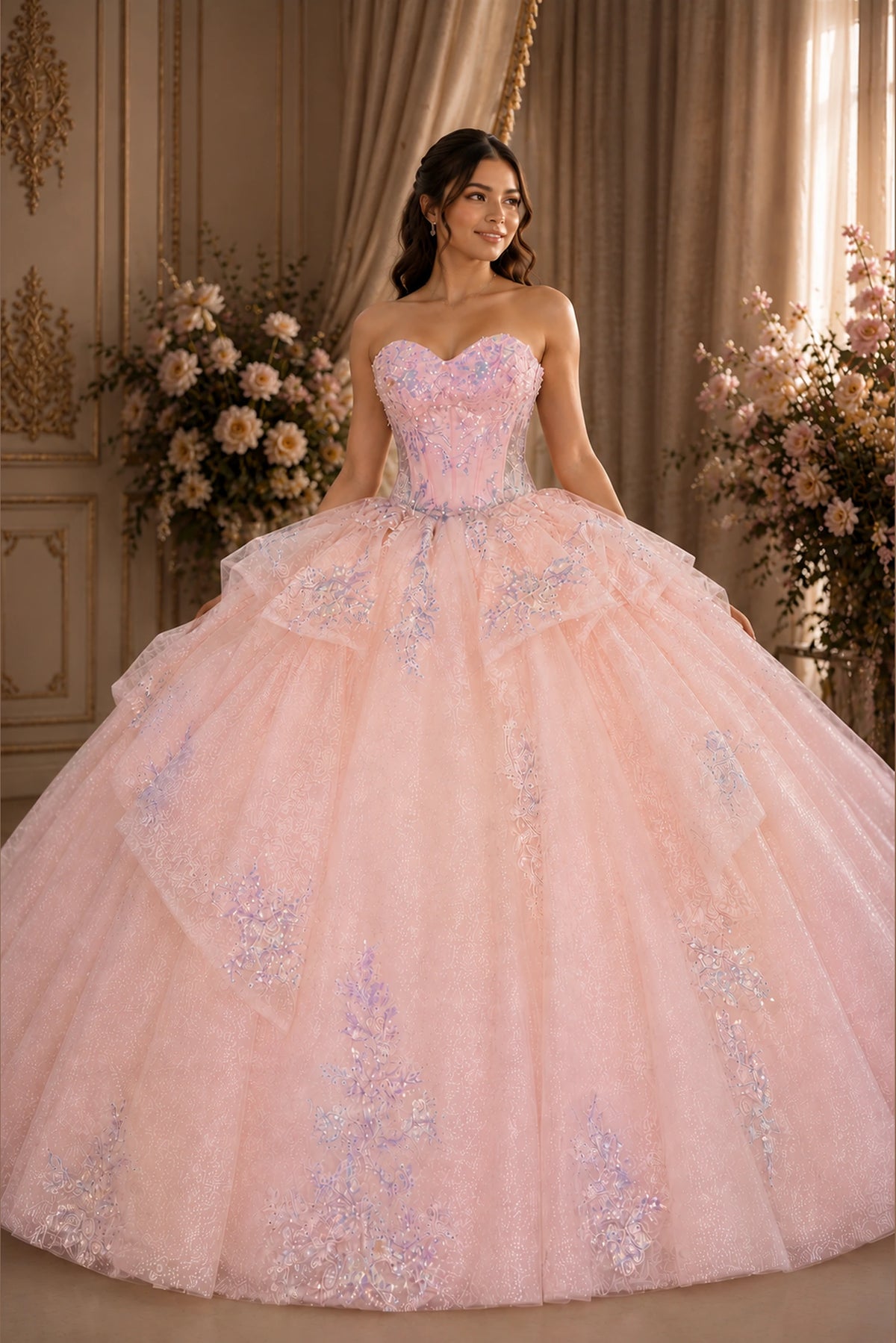 Blush Pink quinceañera dress showcases silver and lilac embroidered details above cascading ruffles across the back skirt.