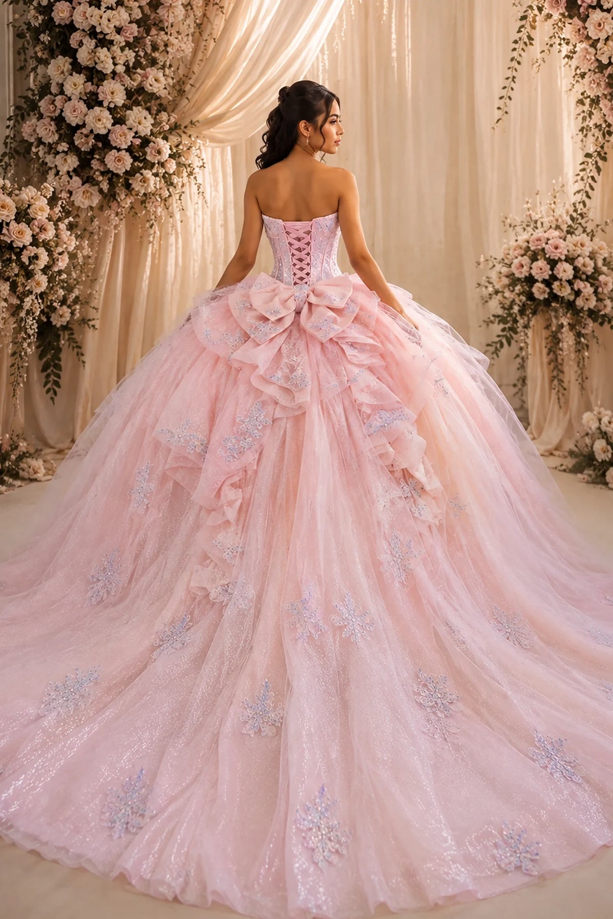 From behind, the Blush Pink quinceañera ball gown reveals a shaped lace-up back and the sweep of the full skirt.