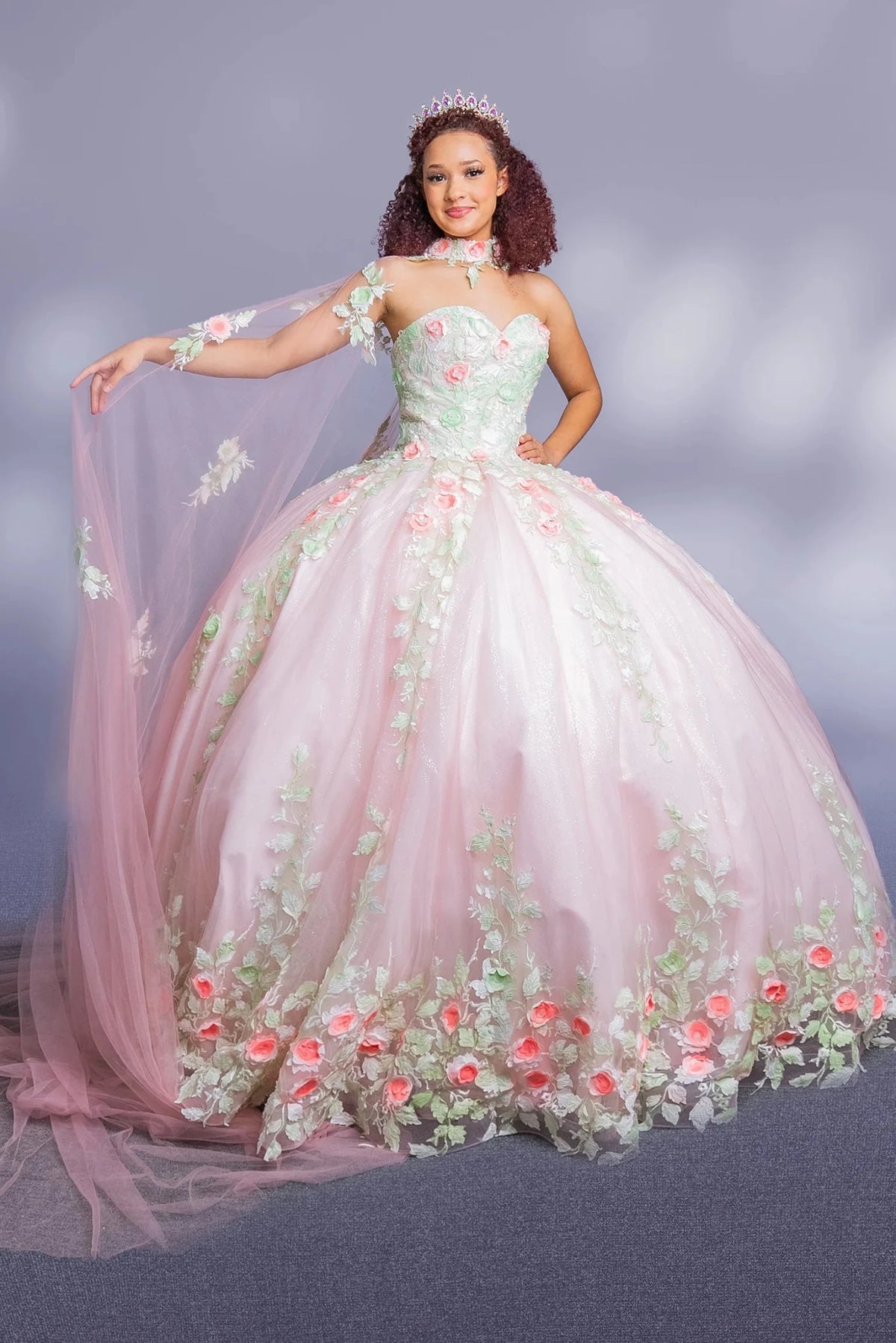 Blush two‑tone quinceañera ball gown with floral detailing, strapless neckline and detachable cape