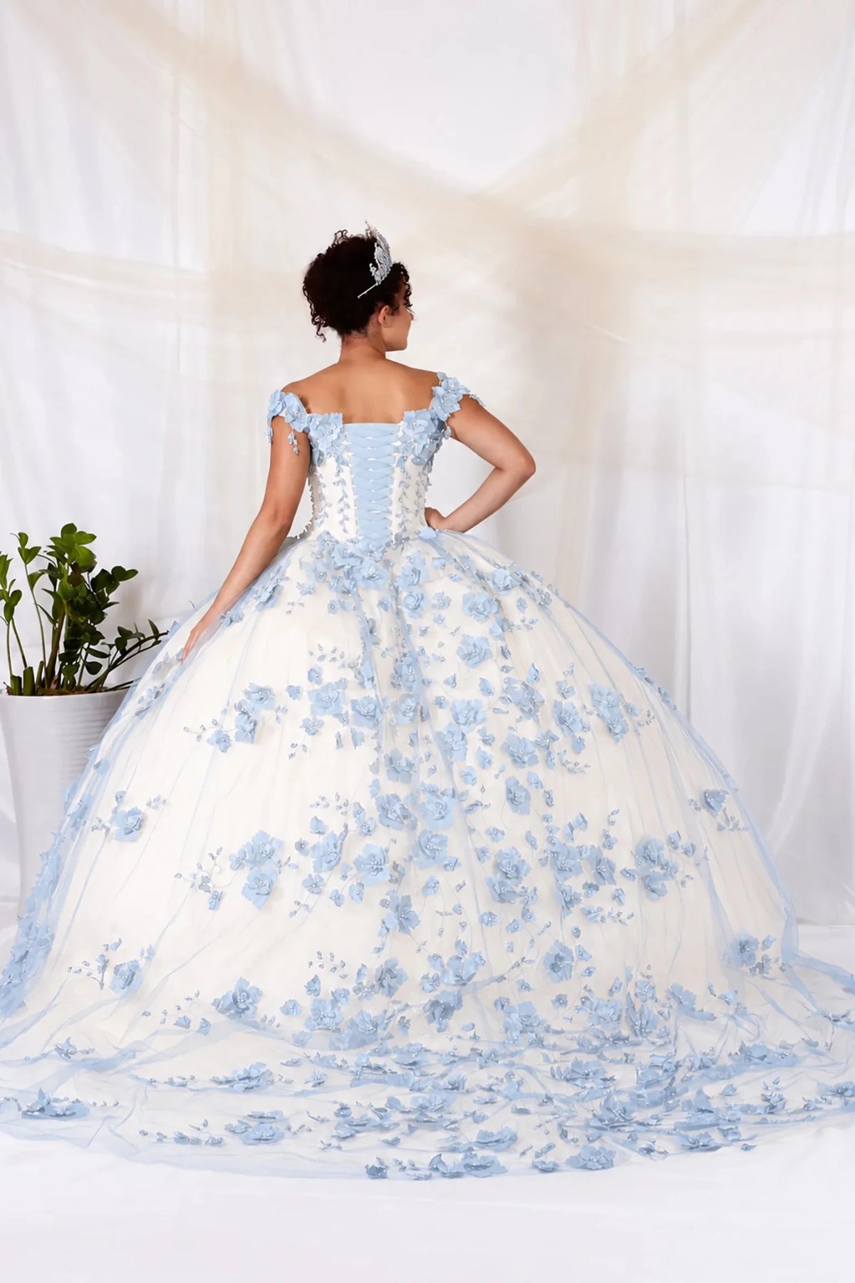 Light blue quinceañera ball gown with floral embroidery, sheer bodice and long train