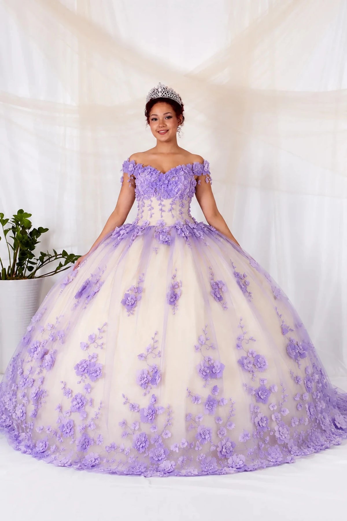 Lilac quinceañera ball gown with off‑shoulder neckline, floral applique, layered train and cream tulle