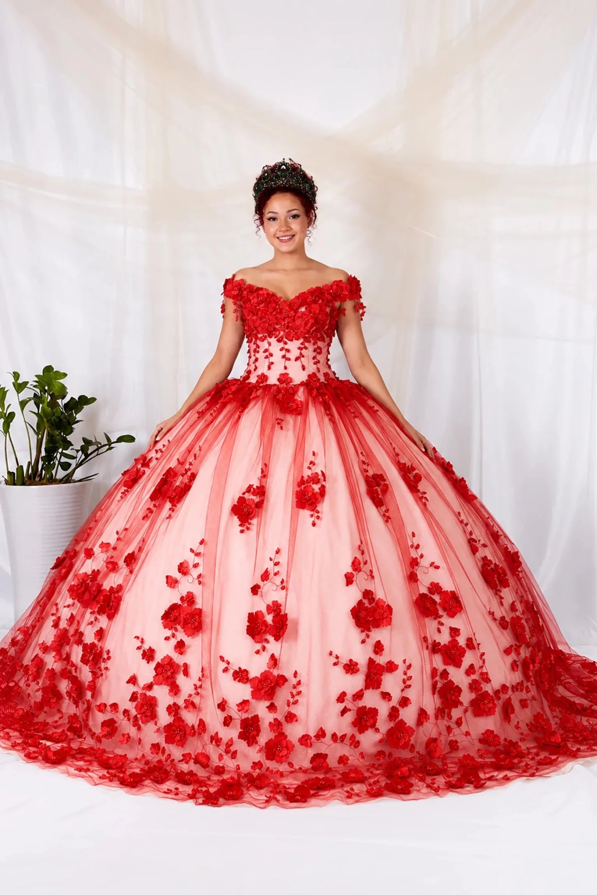 Red quinceañera ball gown with off‑shoulder neckline, floral applique and long ivory tulle train