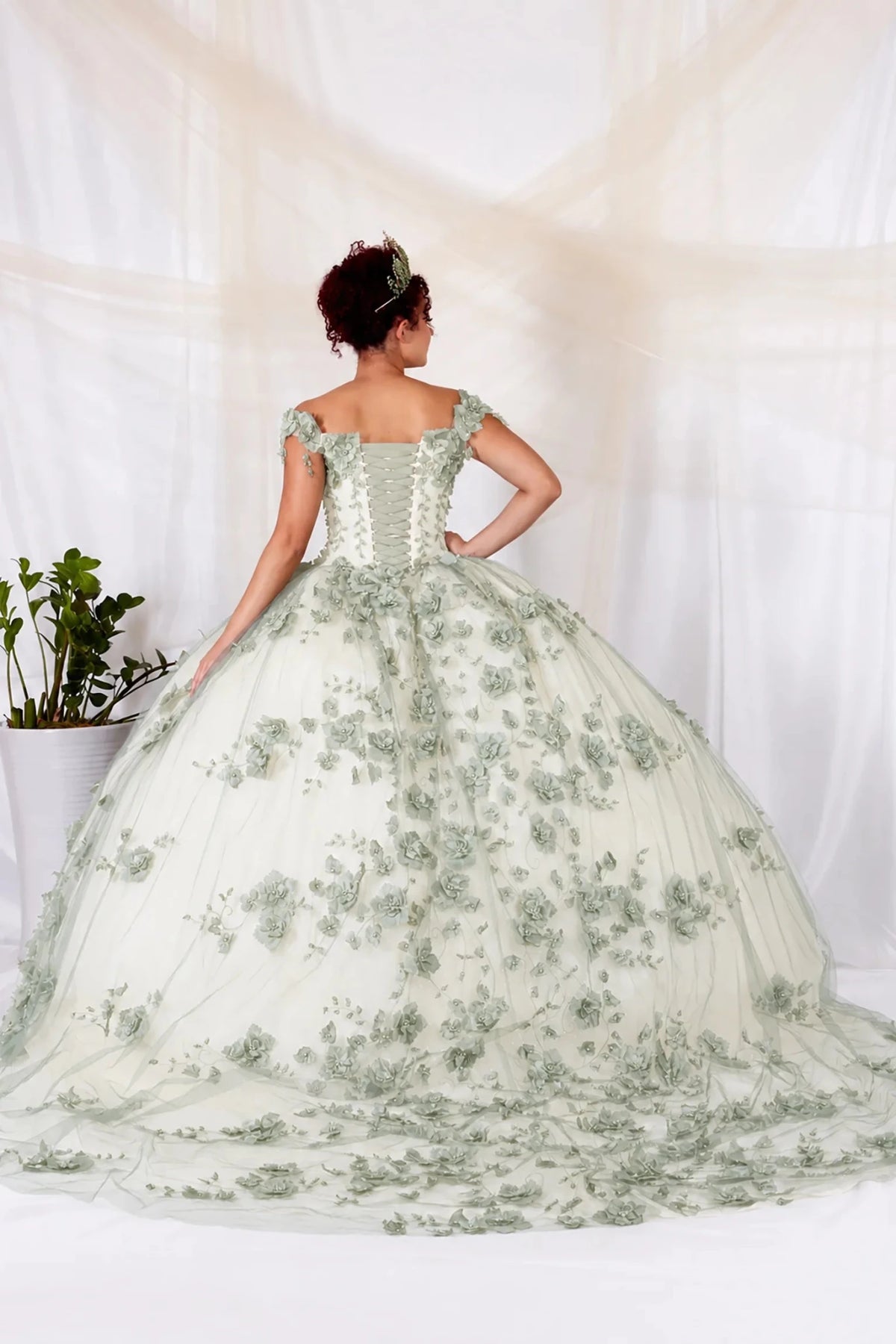 Sage quinceañera ball gown with off‑shoulder neckline, floral applique and long train