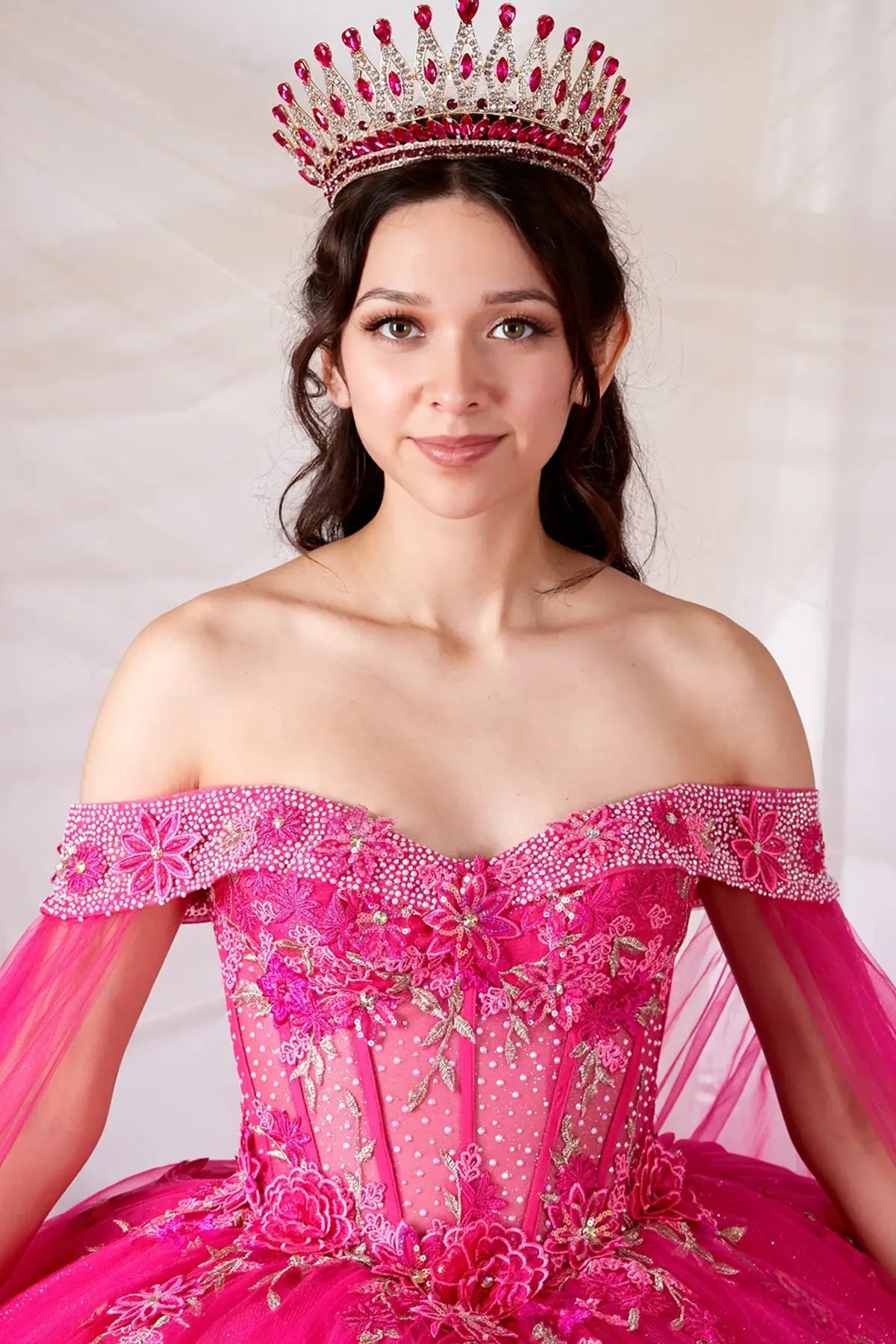 Hot pink quinceañera ball gown with sheer lace bodice and detachable cape