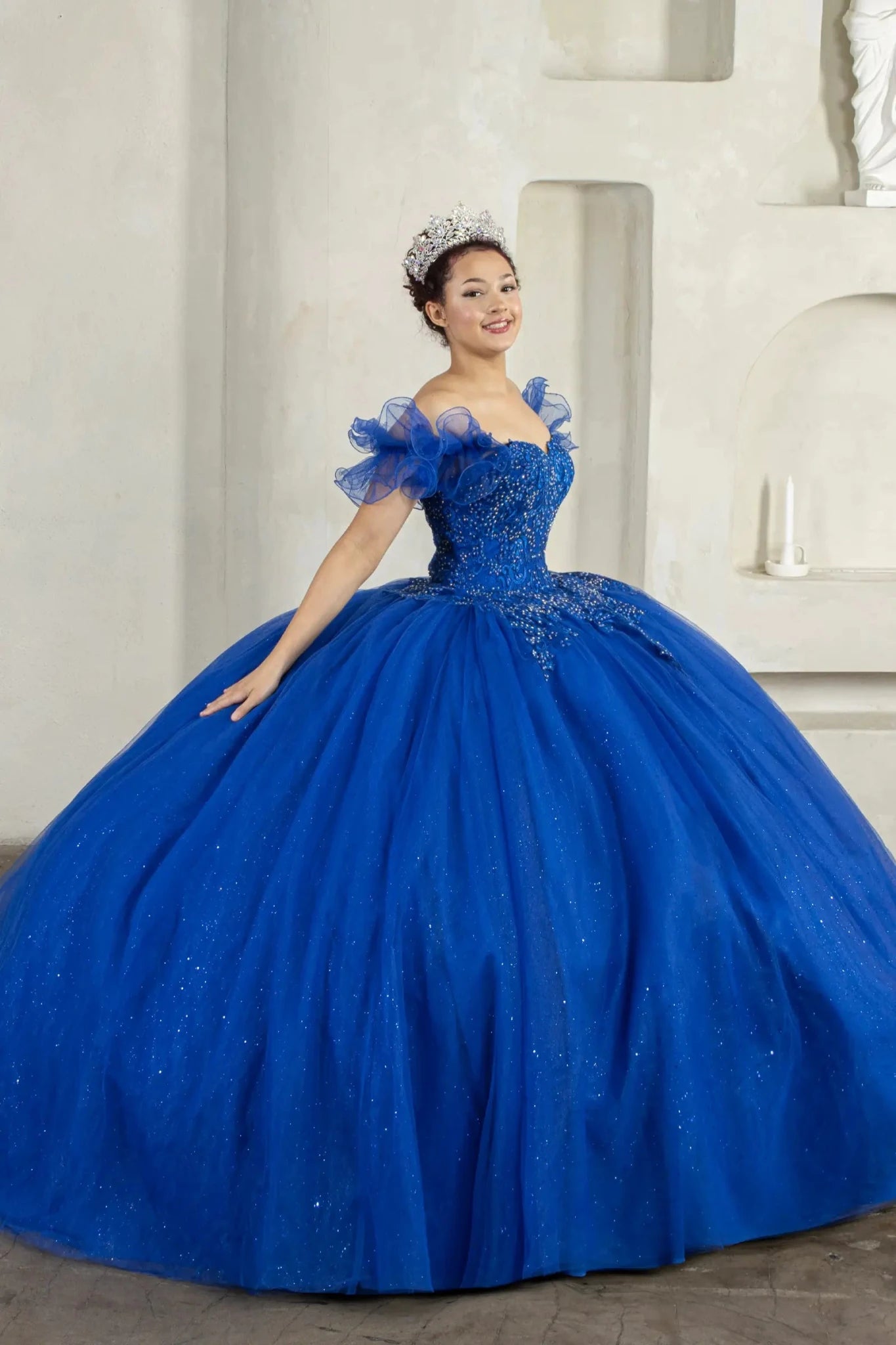 Royal blue quinceañera ball gown with removable ruffle sleeves, beaded bodice, glitter tulle skirt and cape