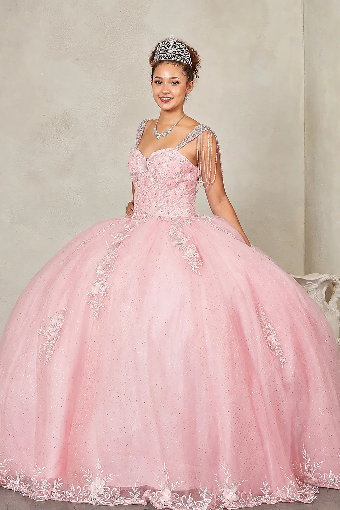 Blush quinceañera ball gown with sweetheart corset bodice framed by bead-fringed cap sleeves