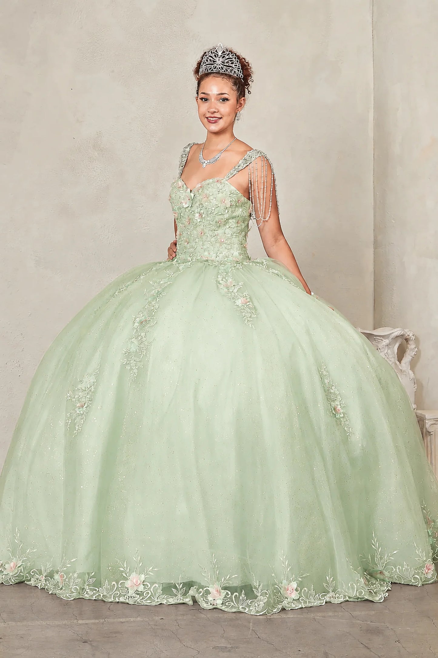 Sage quinceañera ball gown with sweetheart corset bodice framed by bead-fringed cap sleeves