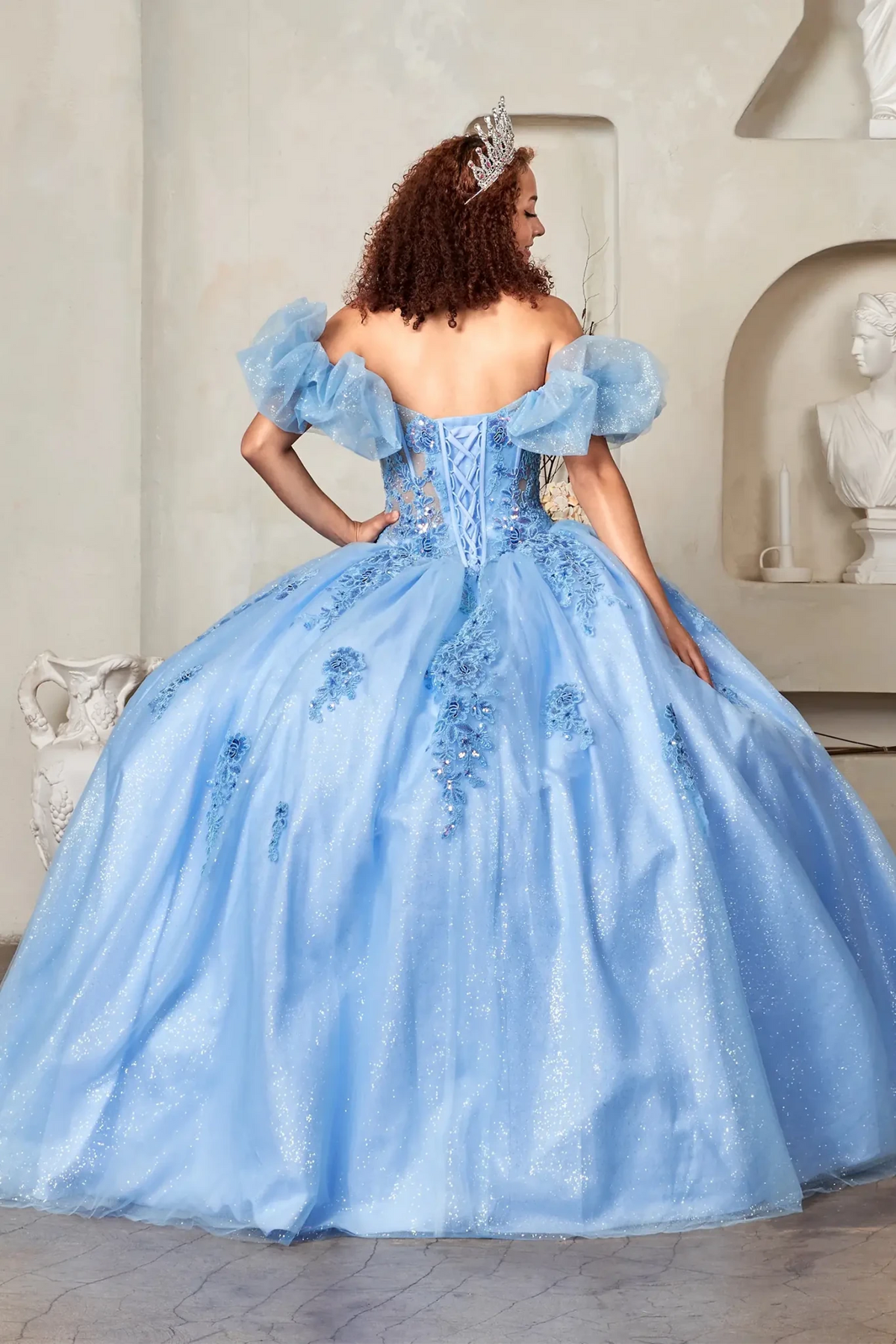 Light blue quinceañera ball gown with illusion sweetheart bodice, corset boning, ruffled straps and floral embroidery