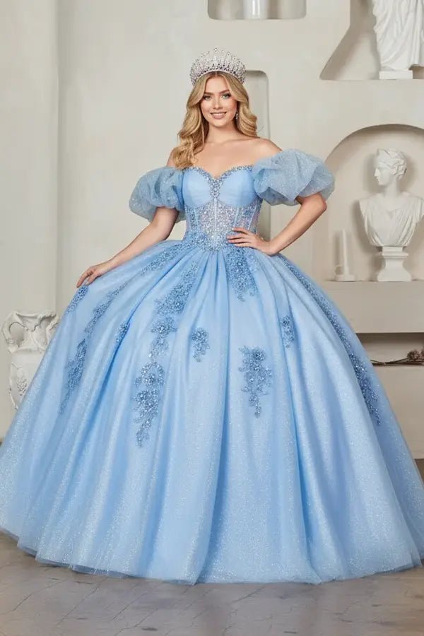 Light blue quinceañera ball gown with illusion sweetheart bodice, corset boning, ruffled straps and flowing skirt