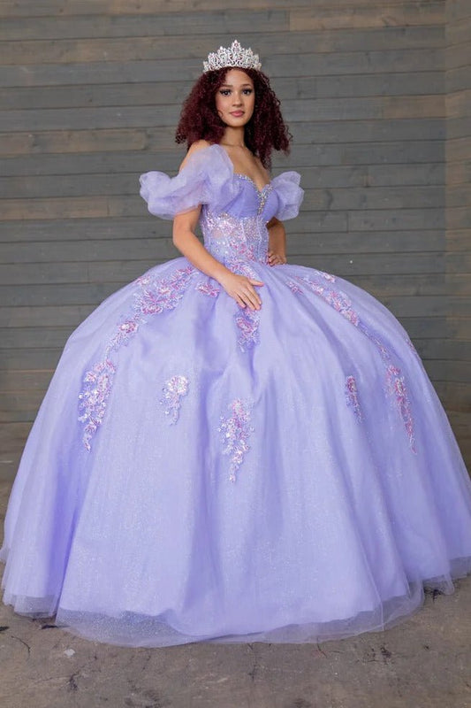 Detailed view highlights lilac quinceañera ball gown with illusion corset boning, ruffled straps, puff sleeves and sweep train skirt.