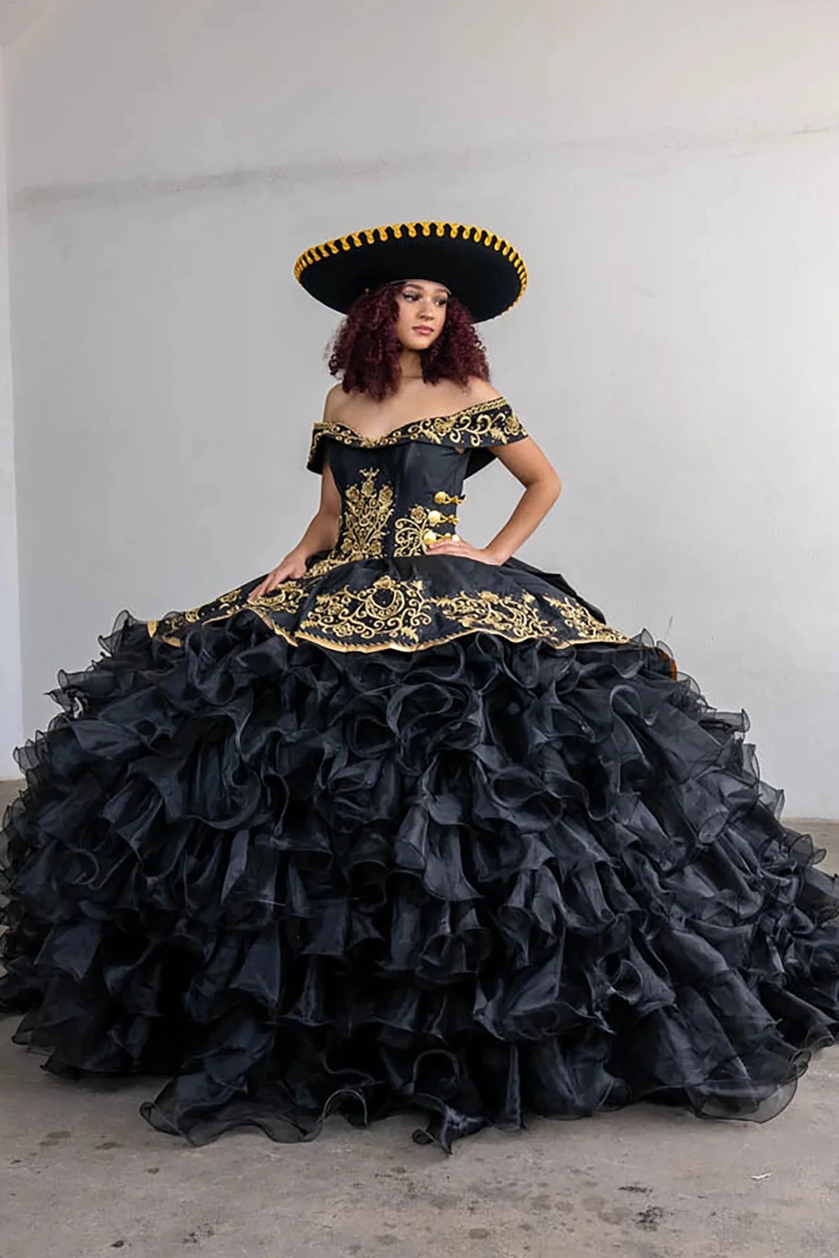 Black quinceañera ball gown with gold embroidery, charra ruffle design and beaded bodice
