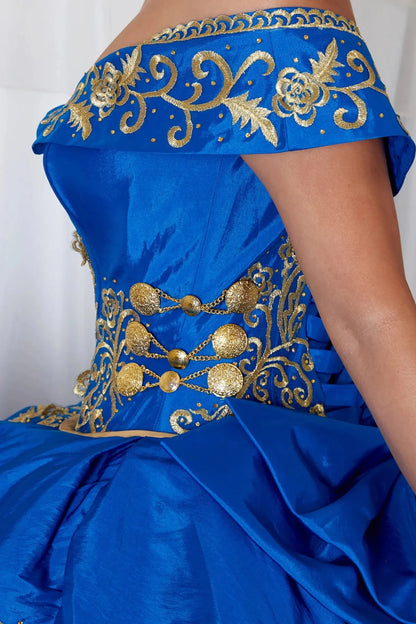 Close-up view reveals royal blue quinceañera ball gown with gold embroidery, charra ruffle design and beaded bodice.