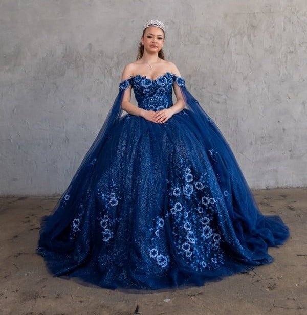 Navy quinceañera ball gown with 3D floral applique, detachable cape and glitter tulle skirt