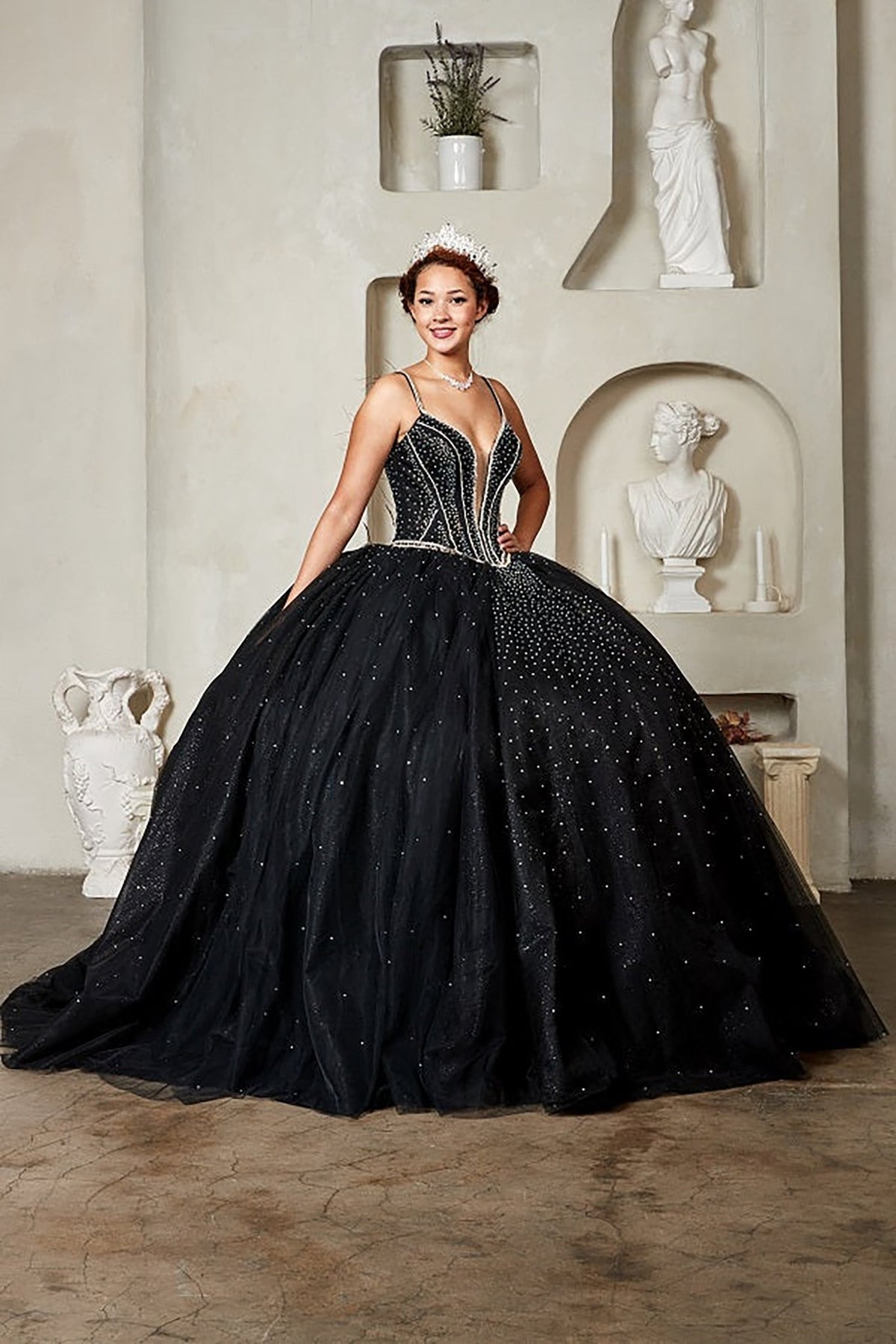 Black quinceañera ball gown with crystal beaded corset, V‑neckline, spaghetti straps and glitter tulle skirt