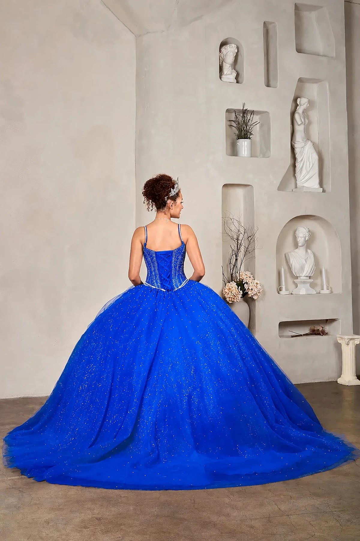 Royal blue quinceañera ball gown with crystal beaded corset, V‑neckline, spaghetti straps and glitter tulle skirt