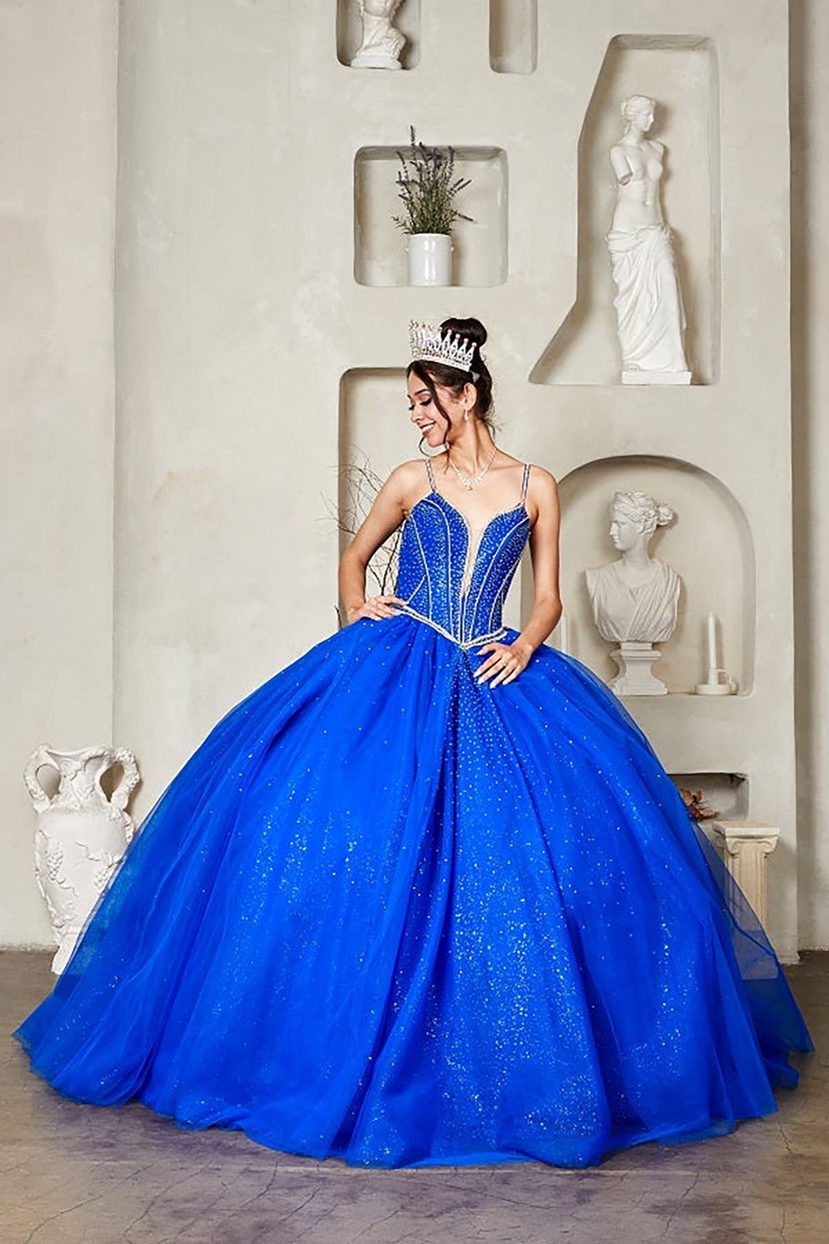 Royal blue quinceañera ball gown with crystal beaded corset, V‑neckline, spaghetti straps and glitter tulle skirt
