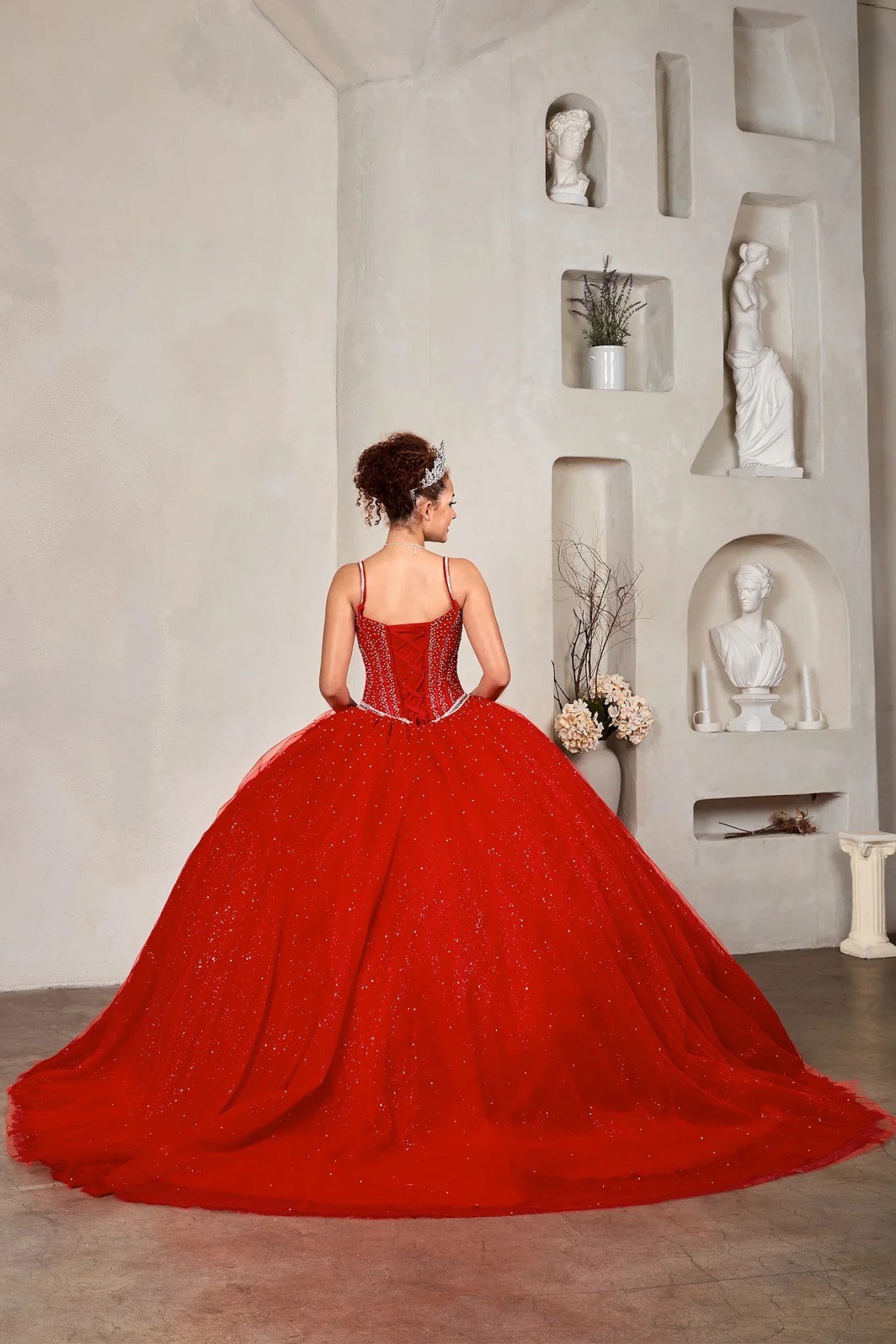 Red quinceañera ball gown with crystal beaded corset, V‑neckline, spaghetti straps and glitter tulle skirt