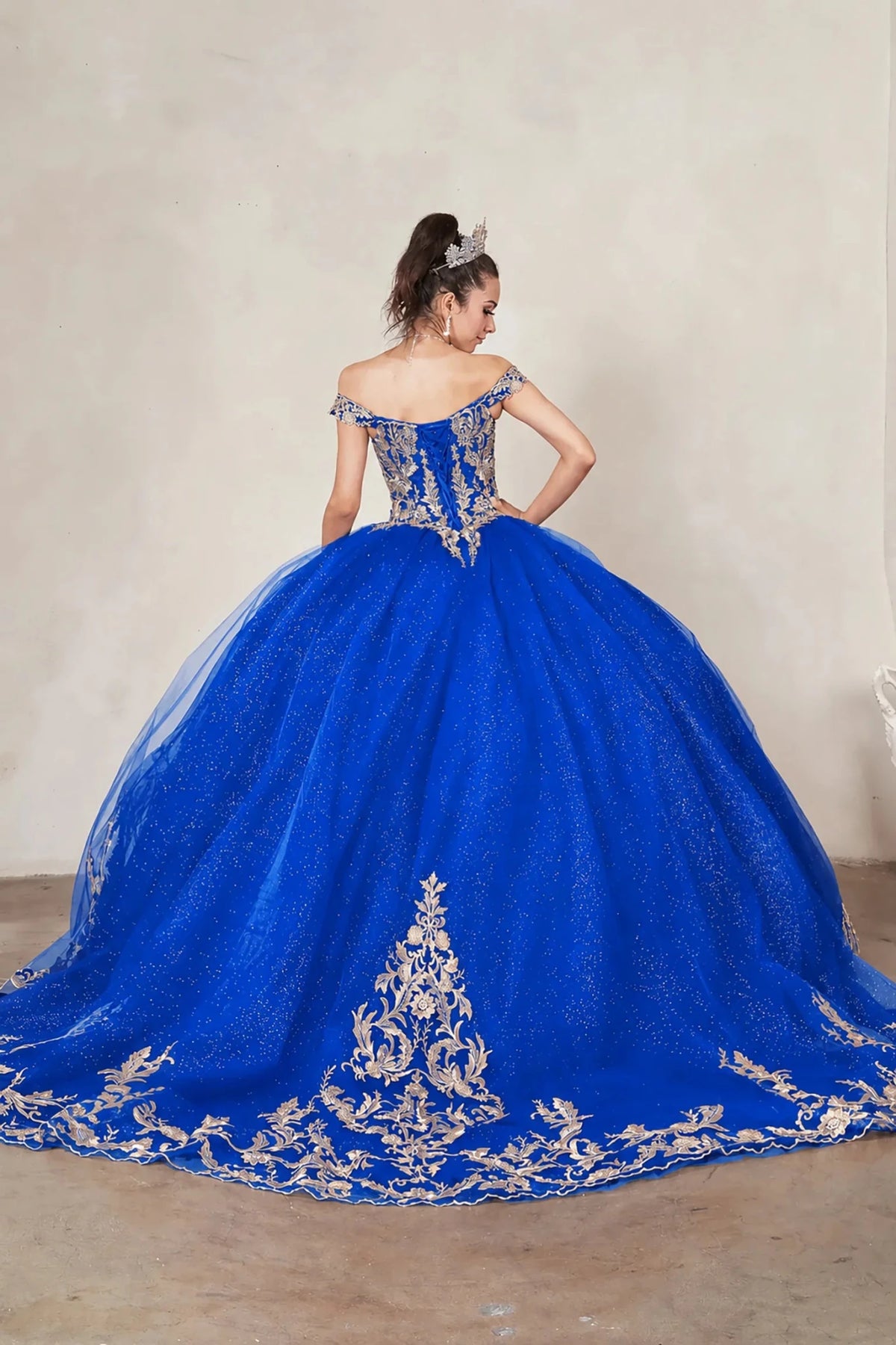 Royal blue quinceañera ball gown with gold embroidered lace applique, glitter tulle overlay and long train
