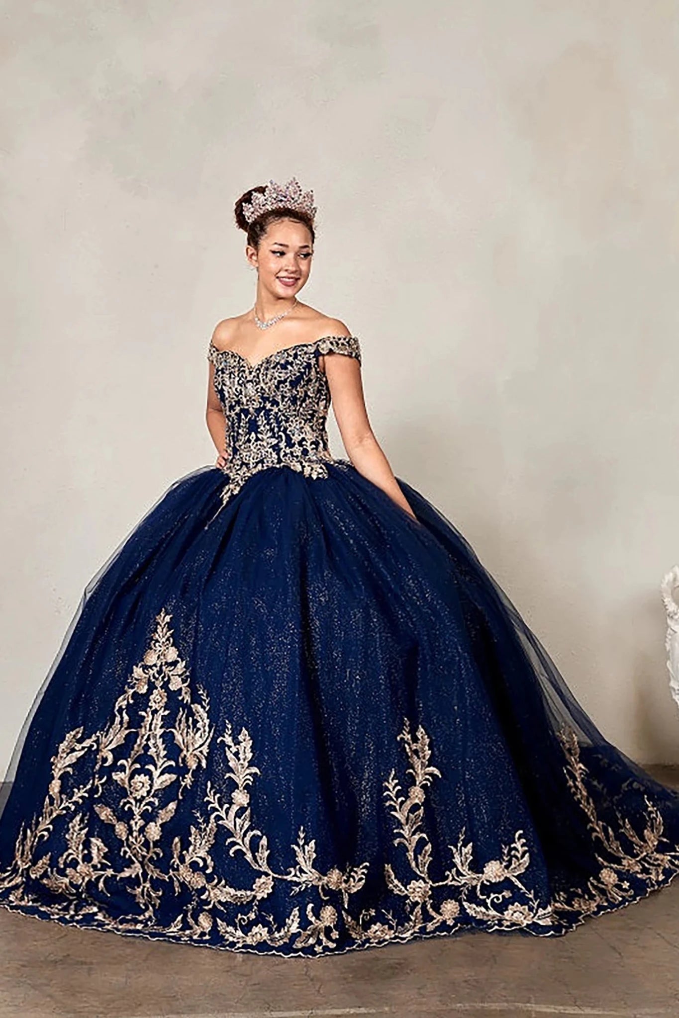 Navy quinceañera ball gown with gold embroidered bodice and glitter tulle overlay skirt