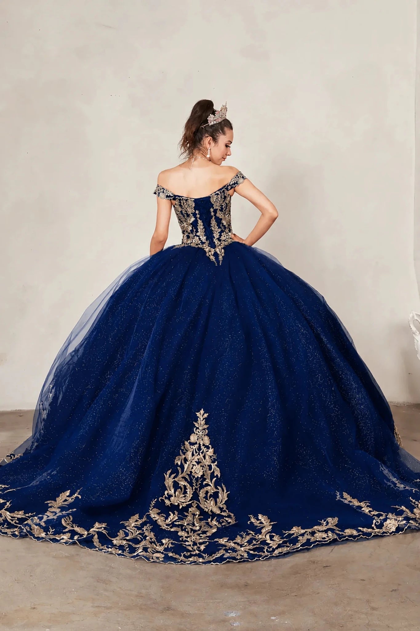 Navy quinceañera ball gown with gold embroidered lace applique, lace‑up back and long train