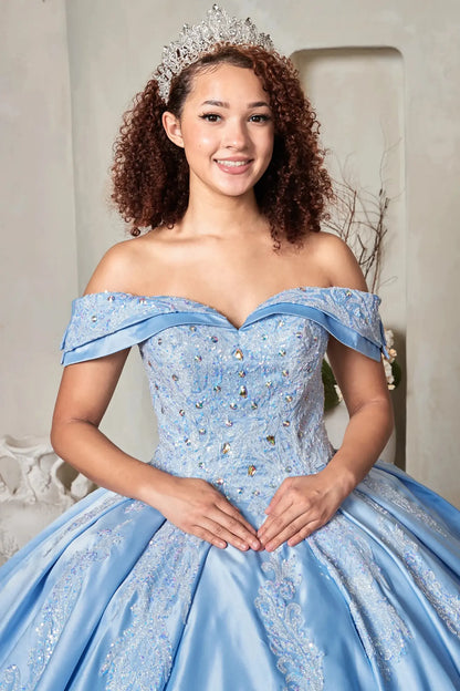 Woman in a light blue off-shoulder quincenera gown with big rhinestones and embroidery
