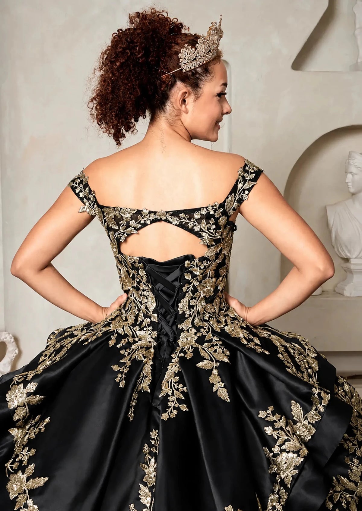 Black quinceañera ball gown with beaded gold embroidery, glitter layered skirt and lace‑up corset