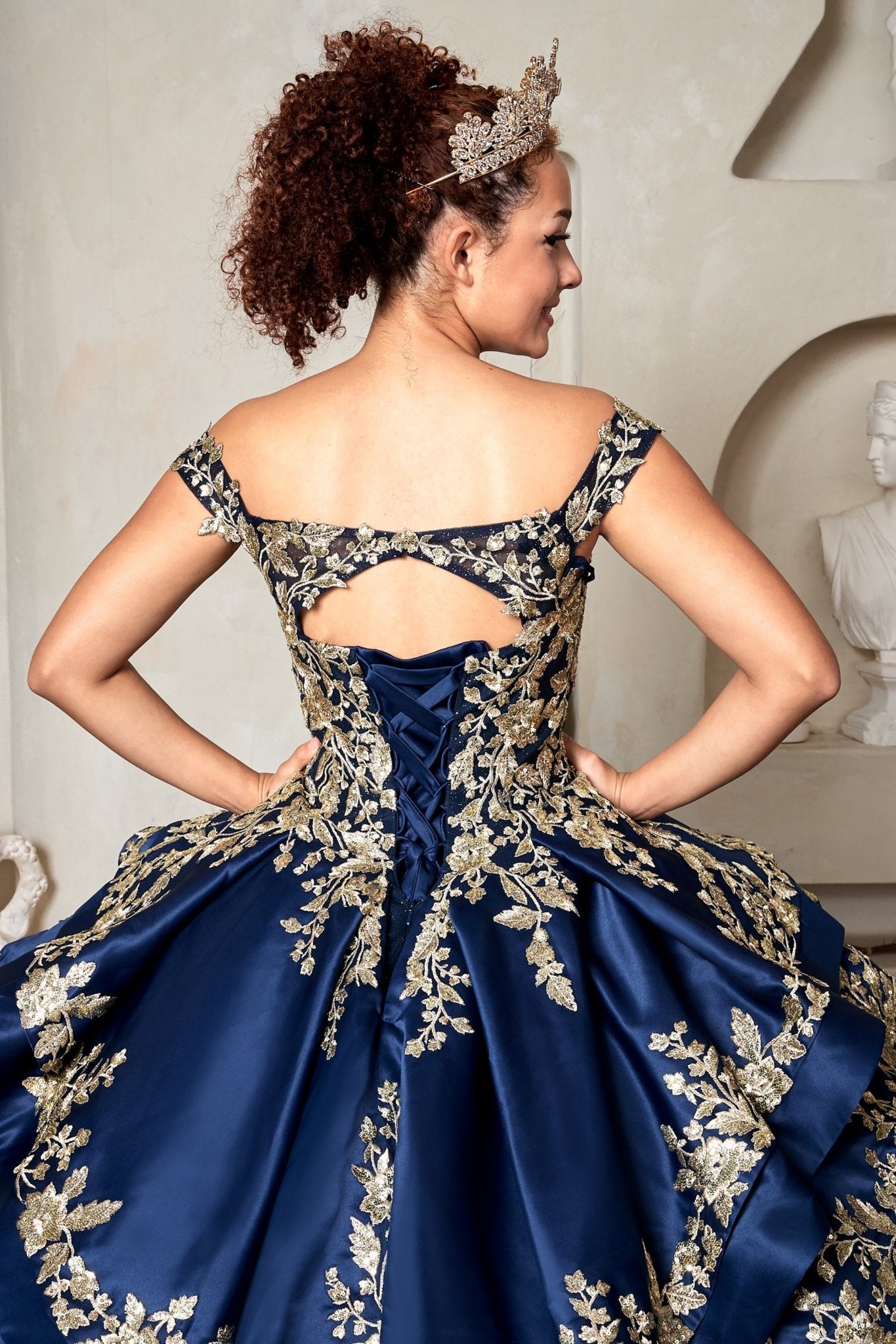 Navy quinceañera ball gown with beaded gold embroidery, glitter layered skirt and lace‑up corset