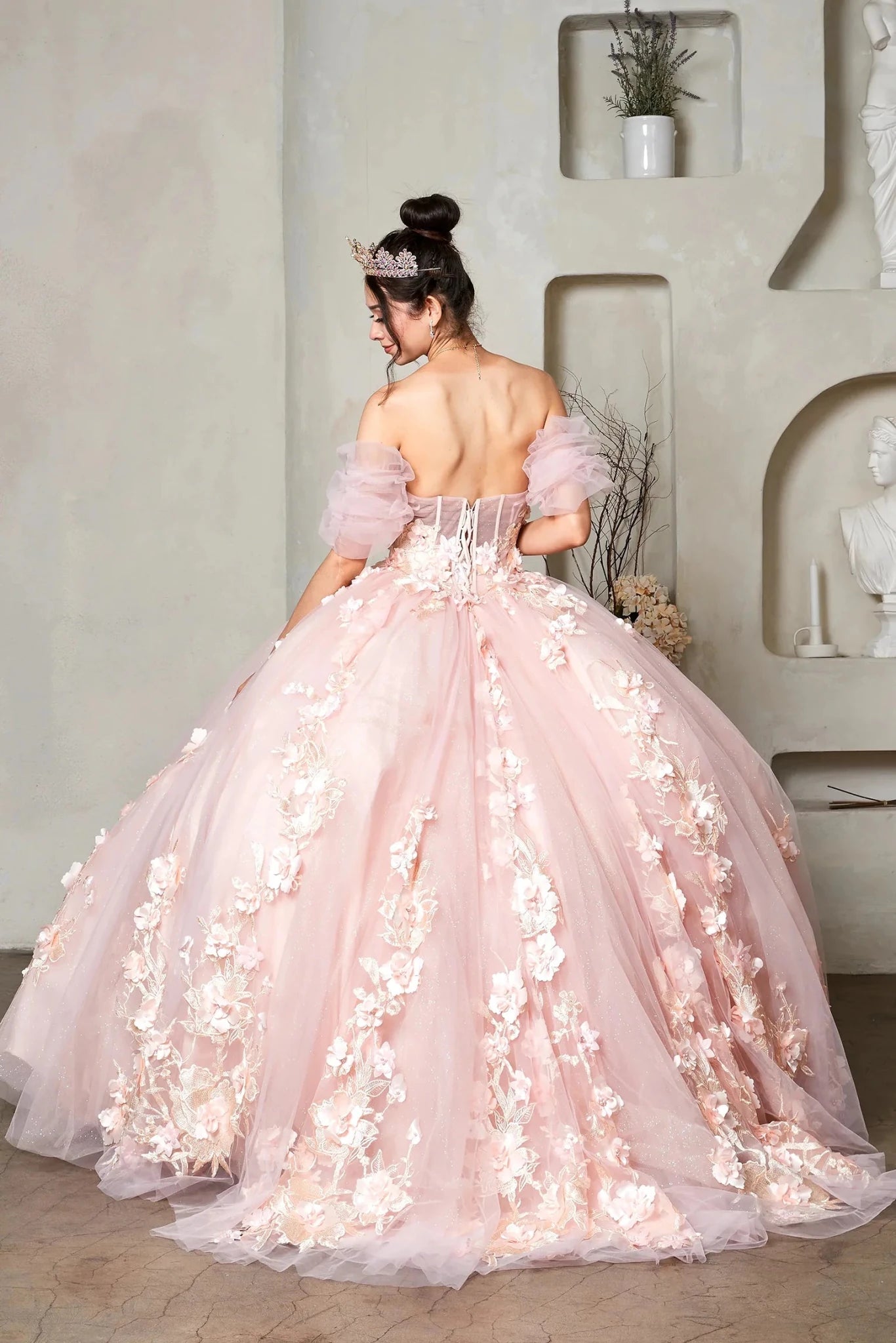 a voluminous light pink quinceanera dress with long train and 3d florals