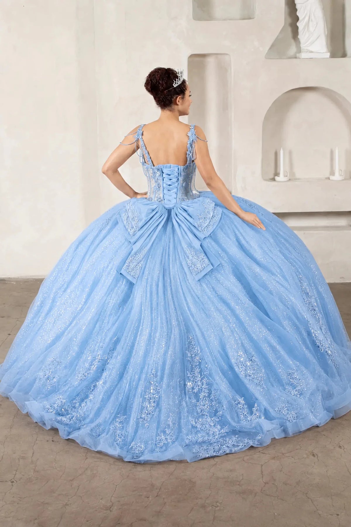 Light blue quinceañera ball gown with sheer bodice, floral embroidery, detachable bow and sparkle tulle