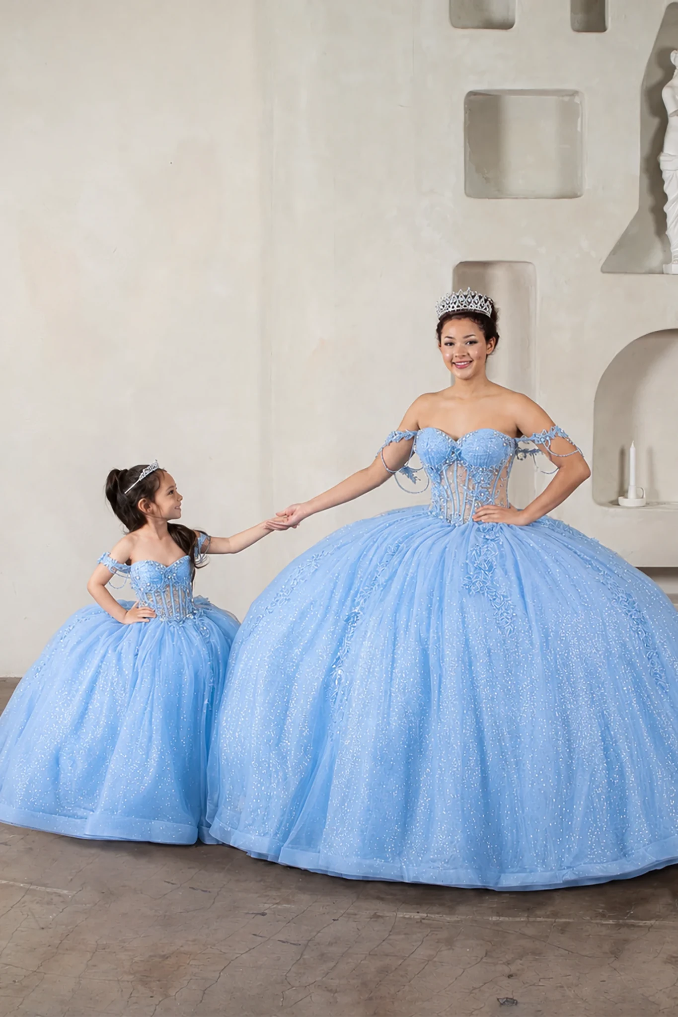 Light blue quinceañera ball gown with sheer bodice, floral embroidery, detachable bow and sparkle tulle