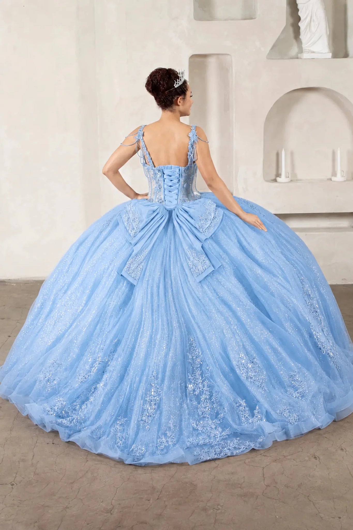 voluminous light blue quinceanera ball gown with jewel detailing, a large bow at the back and long train