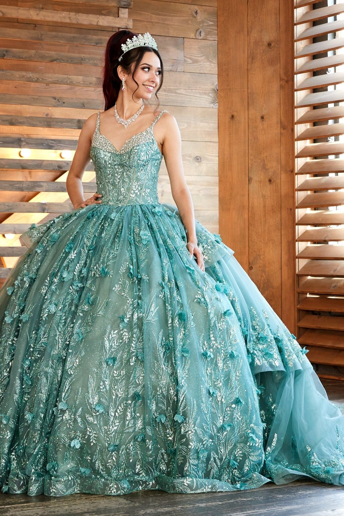 Sage quinceañera ball gown with V‑neckline, crystal trim and glitter fabric